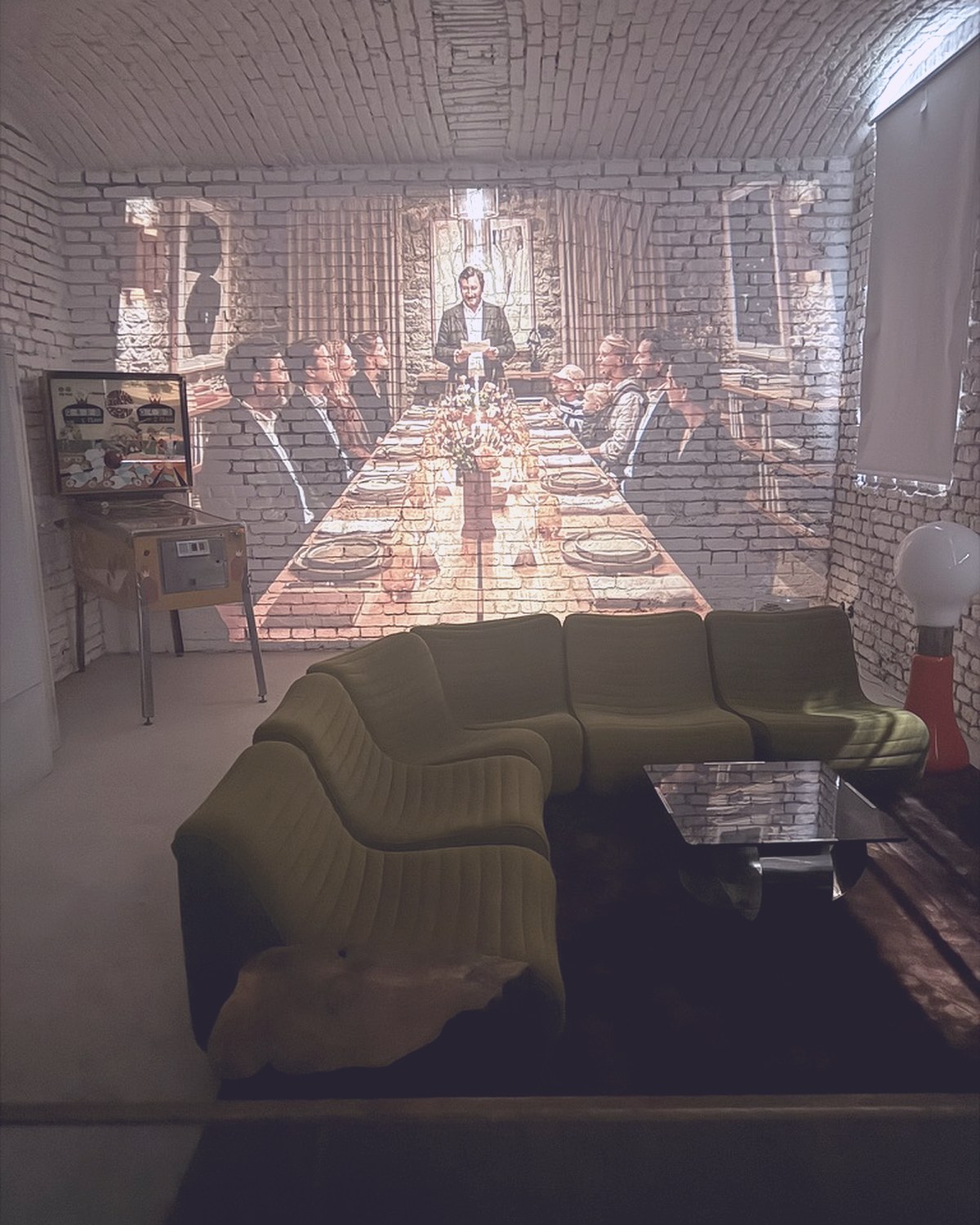 A large projection on the brick wall above the green lounge