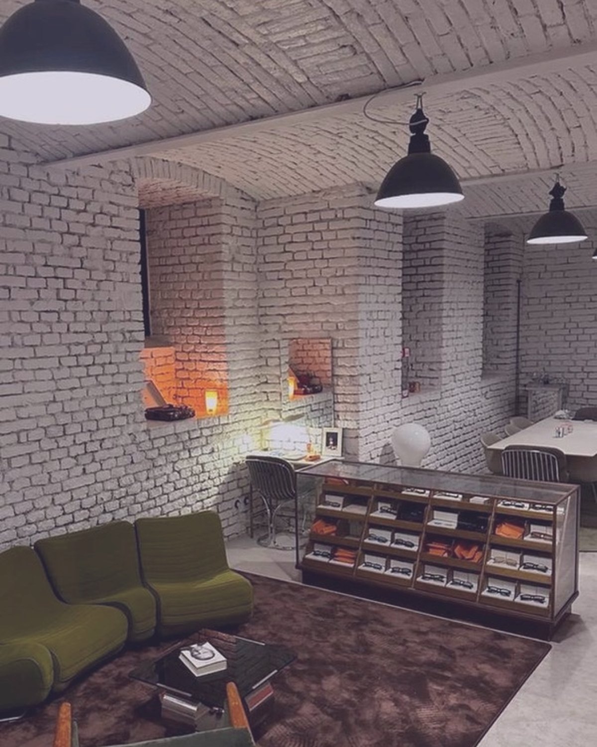 The green lounge with the eyewear showcase, glass table and warm boutique light